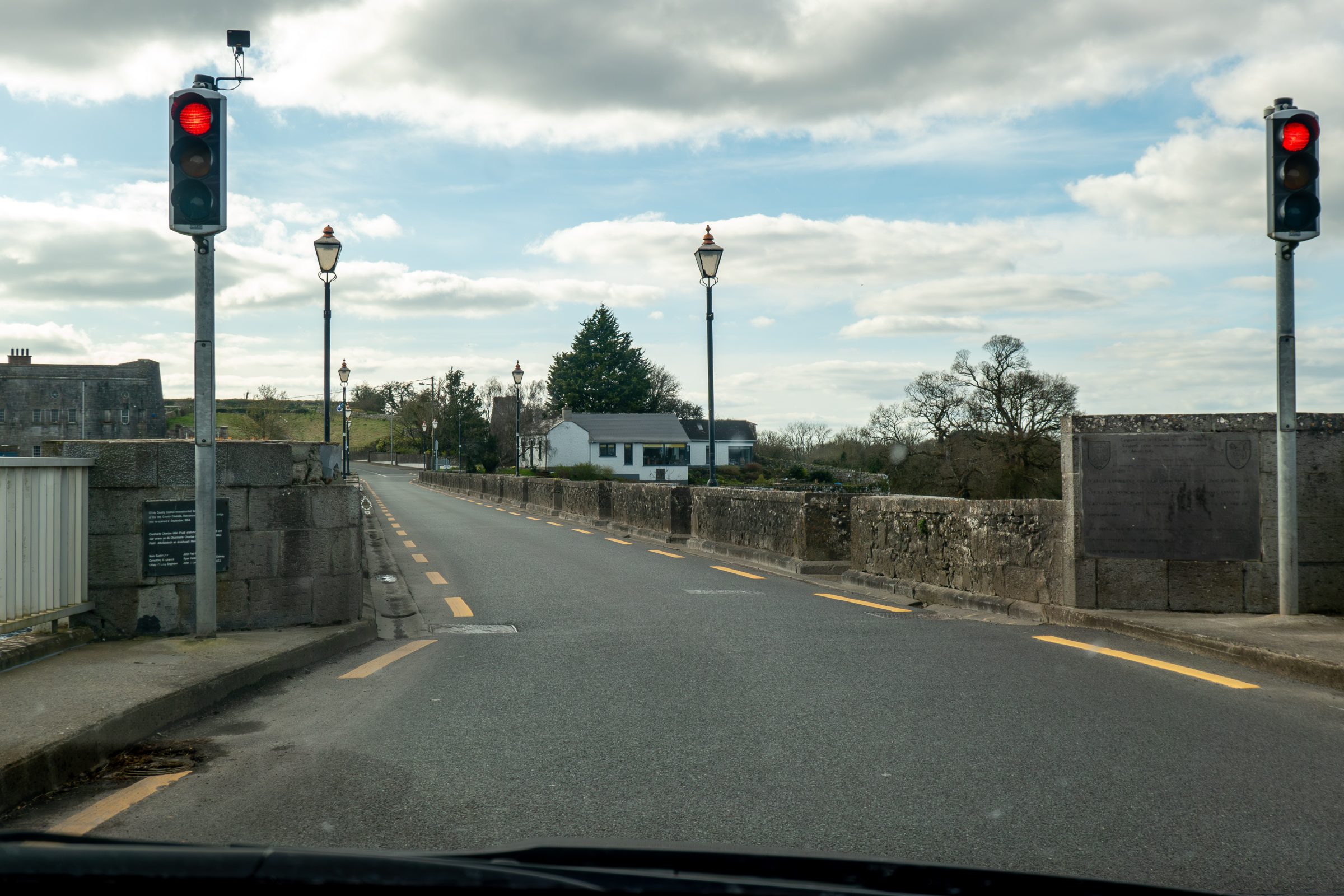 A single lane bridge with lights to direct traffic.